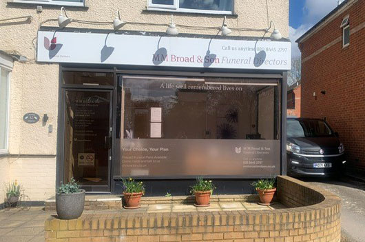 M M Broad & Son Funeral Directors front window on a sunny day